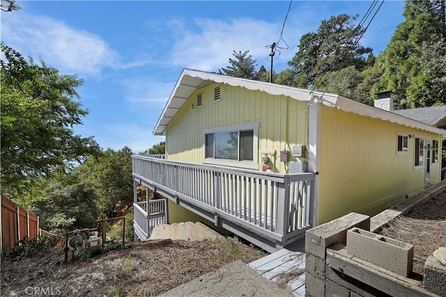 view of property exterior with a deck and a chimney
