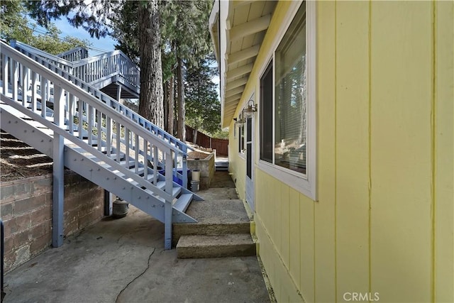 view of home's exterior with stairs and fence