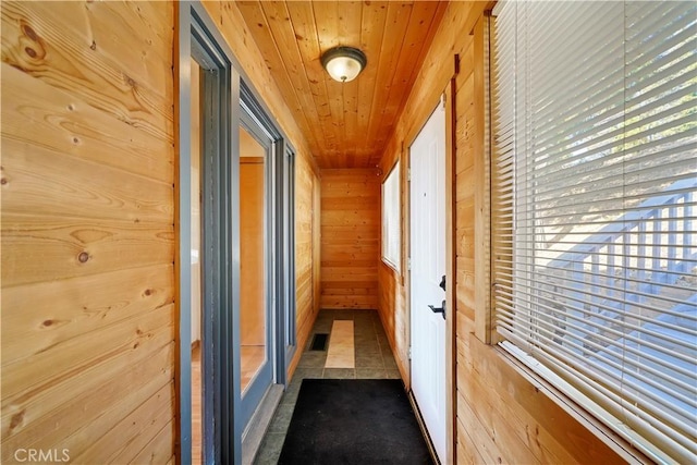 corridor featuring visible vents, wood ceiling, and wooden walls