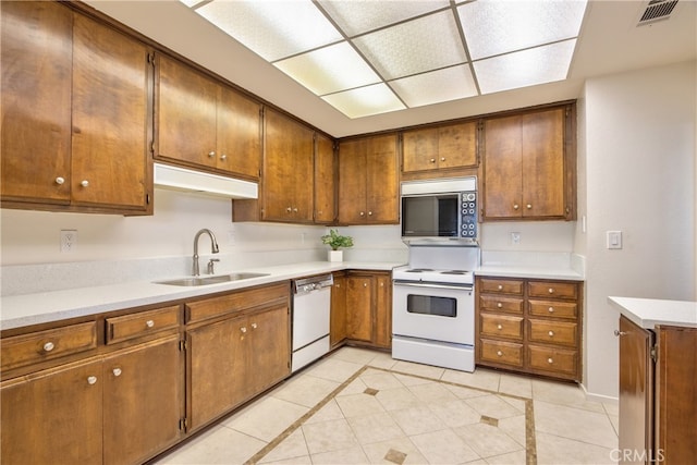 kitchen featuring sink, white appliances, and light tile patterned flooring