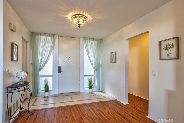 entryway featuring light wood finished floors, visible vents, baseboards, and a textured ceiling