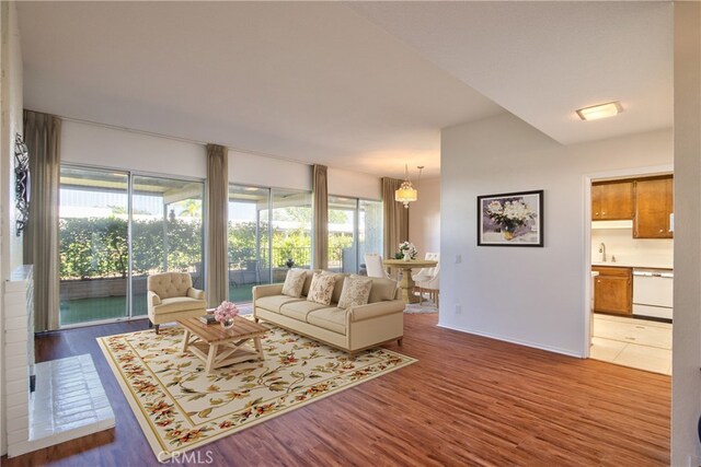 living room featuring plenty of natural light, wood-type flooring, and sink