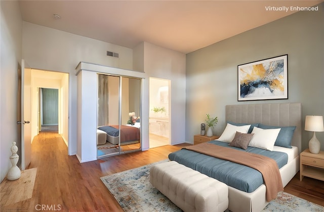 bedroom with baseboards, visible vents, connected bathroom, light wood-type flooring, and a closet