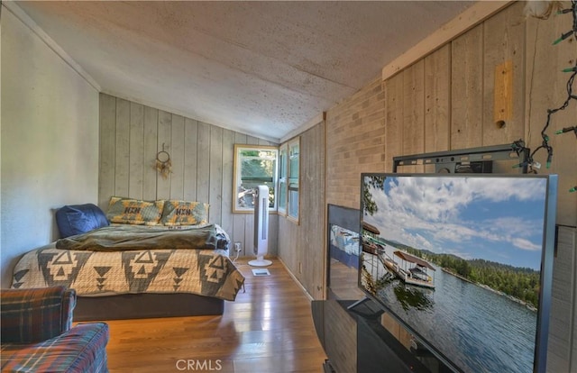 bedroom with wood walls, dark wood-type flooring, and lofted ceiling