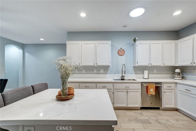 kitchen with a kitchen island, a breakfast bar, sink, dishwasher, and white cabinetry