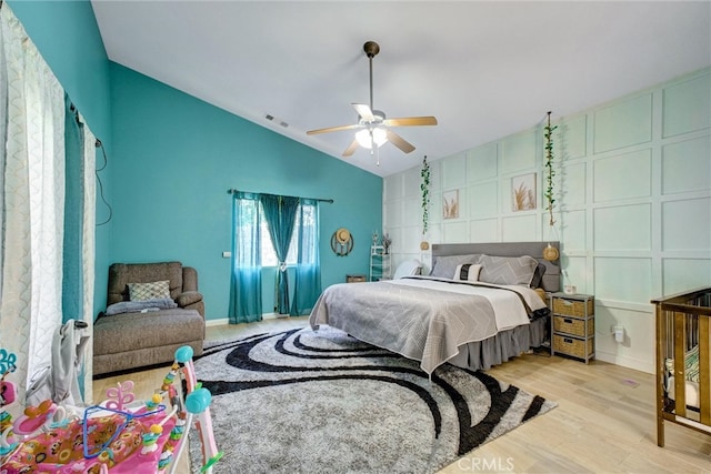 bedroom with ceiling fan, light wood-type flooring, and vaulted ceiling