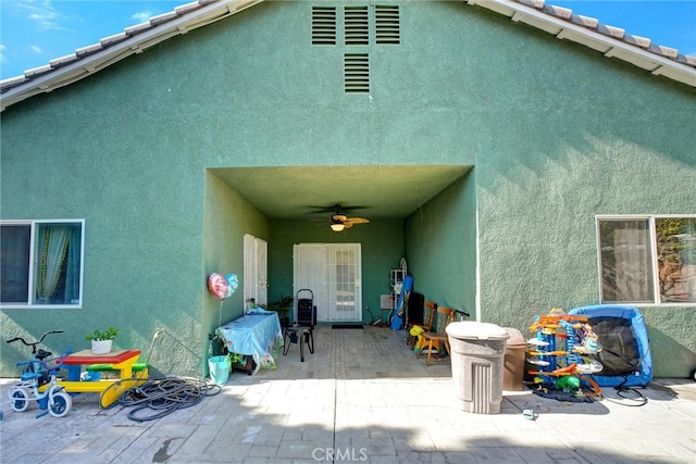 rear view of property featuring ceiling fan and a patio