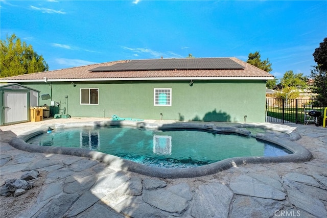 view of swimming pool with a shed and a patio