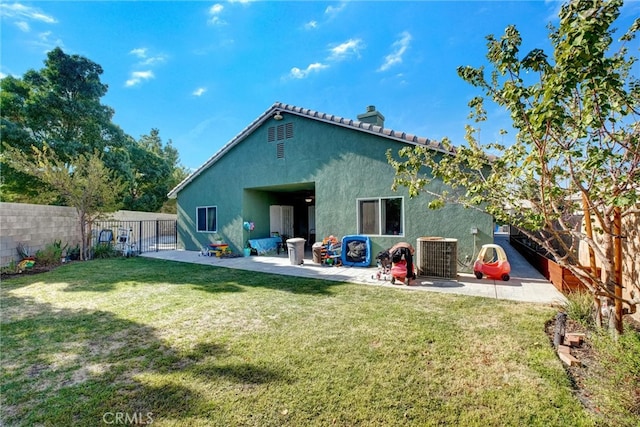 rear view of house featuring cooling unit, a lawn, and a patio