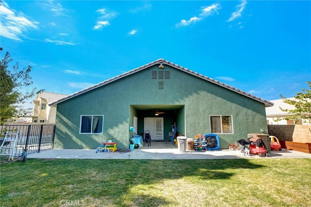 rear view of property featuring a lawn and a patio area