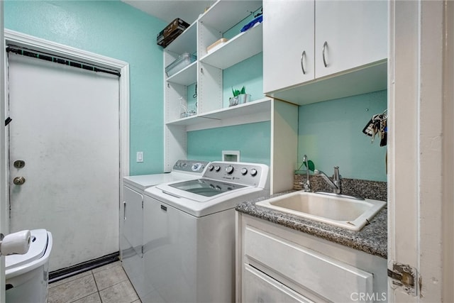 clothes washing area with cabinets, washer and dryer, sink, and light tile patterned floors