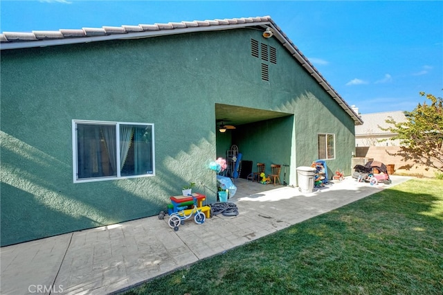 rear view of property featuring a lawn and a patio area