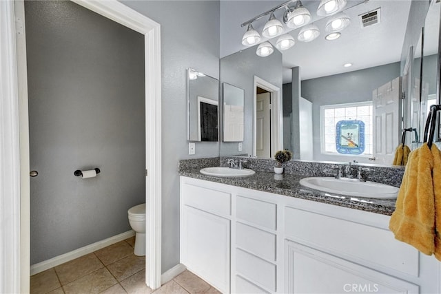 bathroom with tile patterned flooring, vanity, and toilet