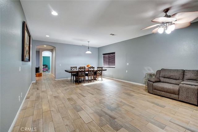 living room with ceiling fan and light hardwood / wood-style flooring