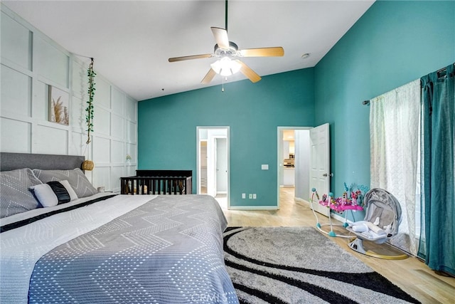 bedroom with ceiling fan, light hardwood / wood-style flooring, and vaulted ceiling