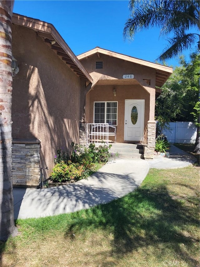 view of exterior entry featuring a yard