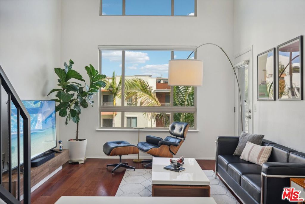 living room featuring hardwood / wood-style flooring and a towering ceiling