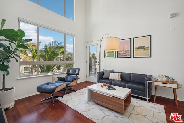 living room with a towering ceiling and light hardwood / wood-style floors