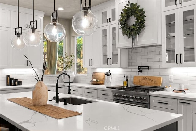 kitchen featuring tasteful backsplash, white cabinets, and hanging light fixtures