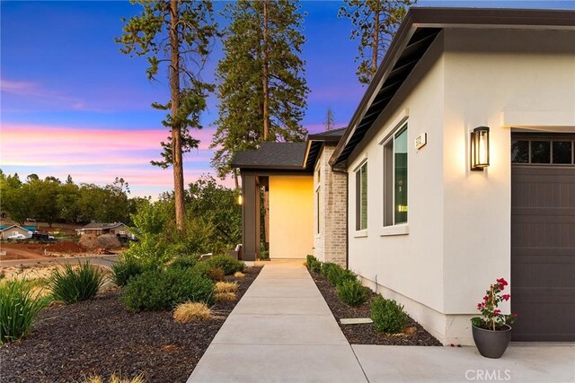 5772 Acorn Ridge Dr, Paradise, CA 95969 - exterior entry at dusk featuring stucco siding