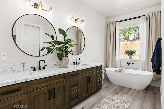 bathroom featuring wood-type flooring, vanity, and a bathtub