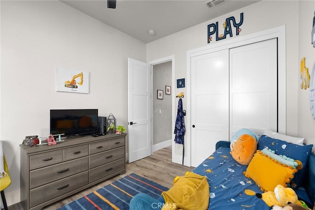 bedroom with ceiling fan, a closet, and light hardwood / wood-style floors