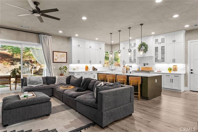 living room featuring ceiling fan and light wood-type flooring