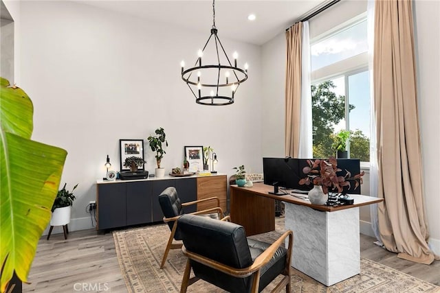 office featuring light wood-type flooring and an inviting chandelier