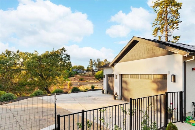 view of home's exterior with a garage and solar panels