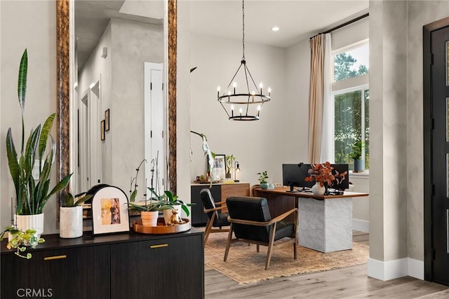 office area with hardwood / wood-style floors and an inviting chandelier