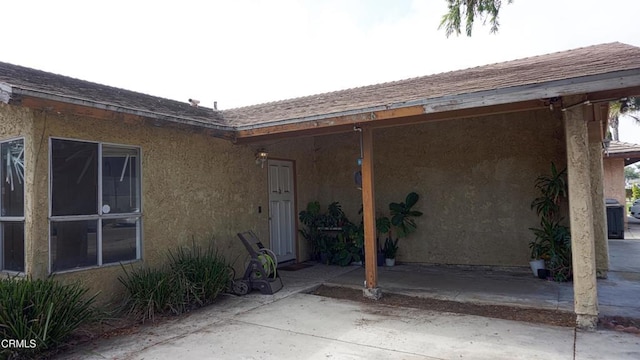 view of exterior entry with a patio