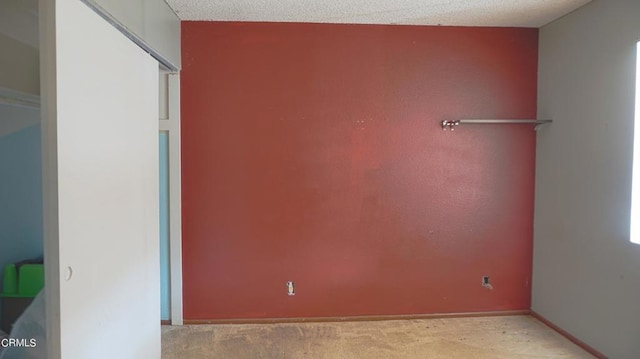 unfurnished bedroom with light colored carpet and a textured ceiling