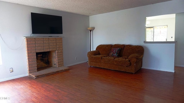 living room featuring a fireplace, dark hardwood / wood-style flooring, and a textured ceiling