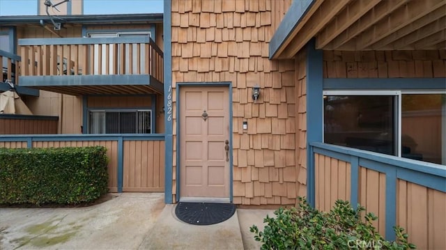 view of exterior entry featuring a balcony