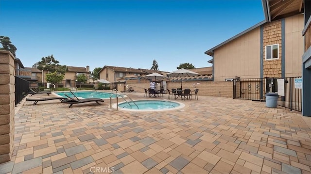 view of pool with a patio area and a community hot tub