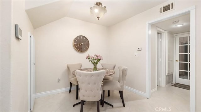 tiled dining space featuring lofted ceiling