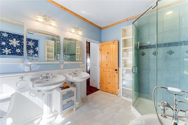 bathroom featuring dual sinks, ornamental molding, and walk in shower