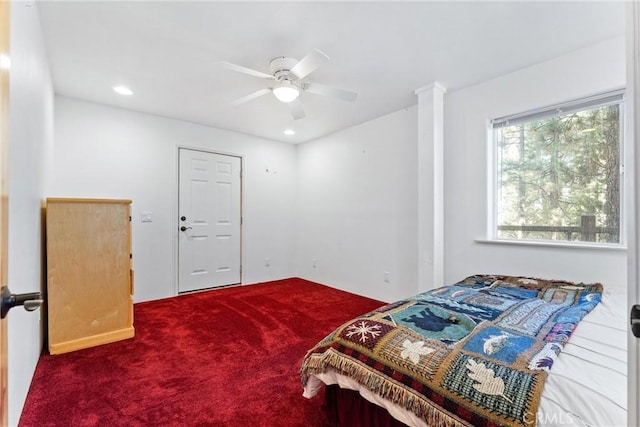 bedroom featuring decorative columns, ceiling fan, and carpet flooring