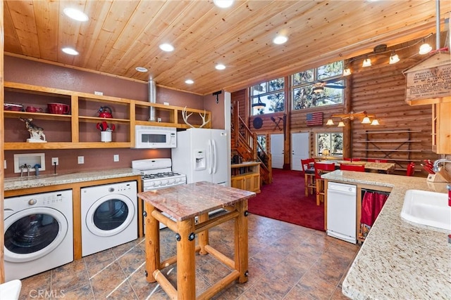 washroom featuring rustic walls, washer and clothes dryer, sink, and wooden ceiling