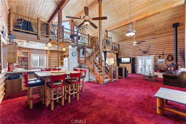 dining room with high vaulted ceiling, carpet flooring, wooden ceiling, french doors, and a wood stove