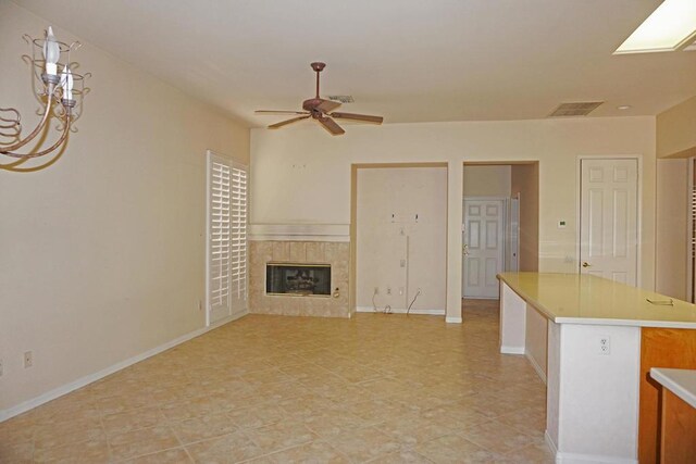 unfurnished living room with ceiling fan and a fireplace