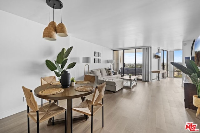 dining space featuring expansive windows and hardwood / wood-style flooring