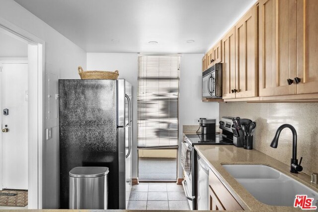 kitchen with light brown cabinetry, appliances with stainless steel finishes, sink, and light tile patterned floors