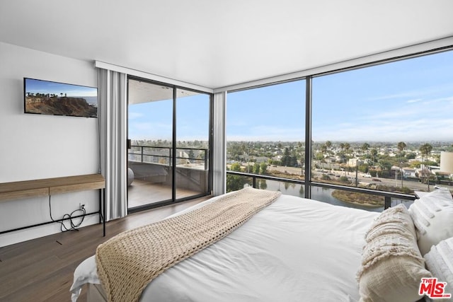 bedroom with a water view, dark hardwood / wood-style floors, and floor to ceiling windows