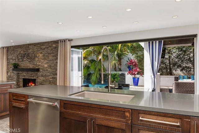 kitchen featuring recessed lighting, a fireplace, a sink, and stainless steel dishwasher