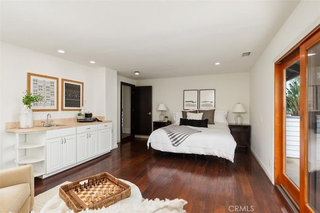 bedroom with baseboards, visible vents, dark wood finished floors, a sink, and recessed lighting