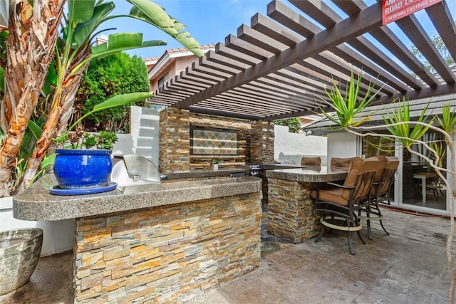 view of patio / terrace featuring outdoor dry bar, area for grilling, and a pergola