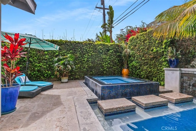 view of swimming pool with an in ground hot tub, a patio, and fence