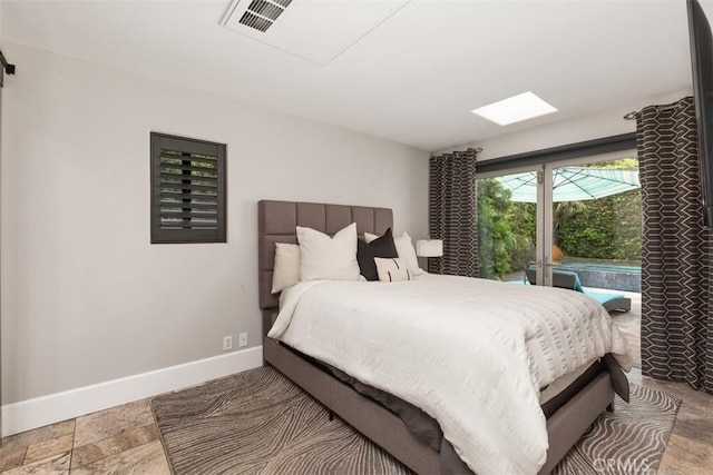 bedroom featuring stone finish flooring and baseboards