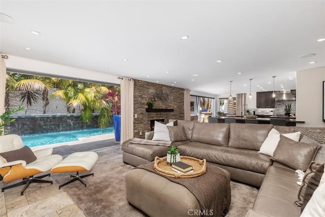 living area with a stone fireplace and recessed lighting